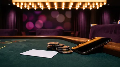 A blank ID card beside casino chips and a smartphone with a dark screen on a table
